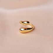 Trendiger verstellbarer Ring aus Edelstahl in Gold auf weichem Stoffhintergrund