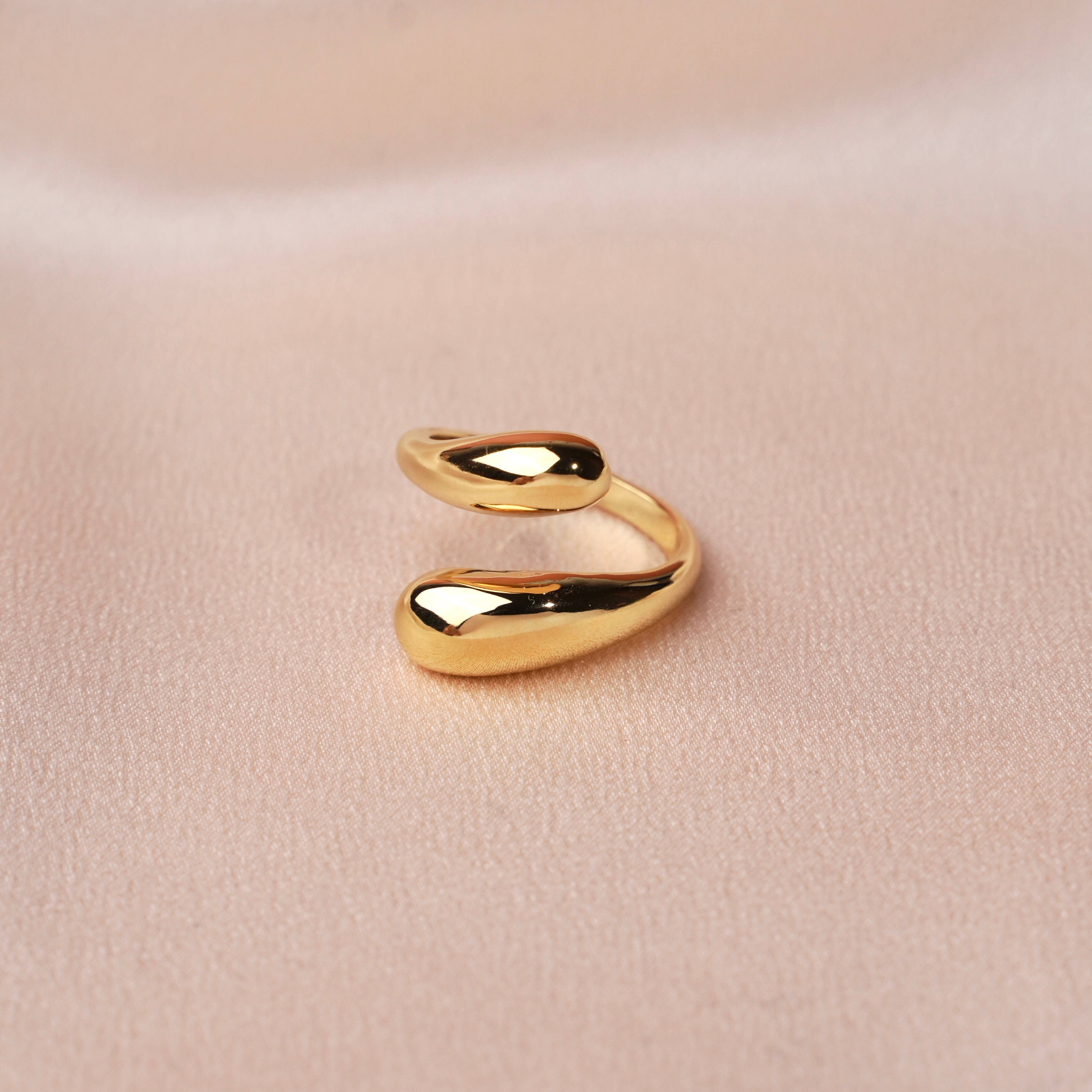 Trendiger verstellbarer Ring aus Edelstahl in Gold auf weichem Stoffhintergrund